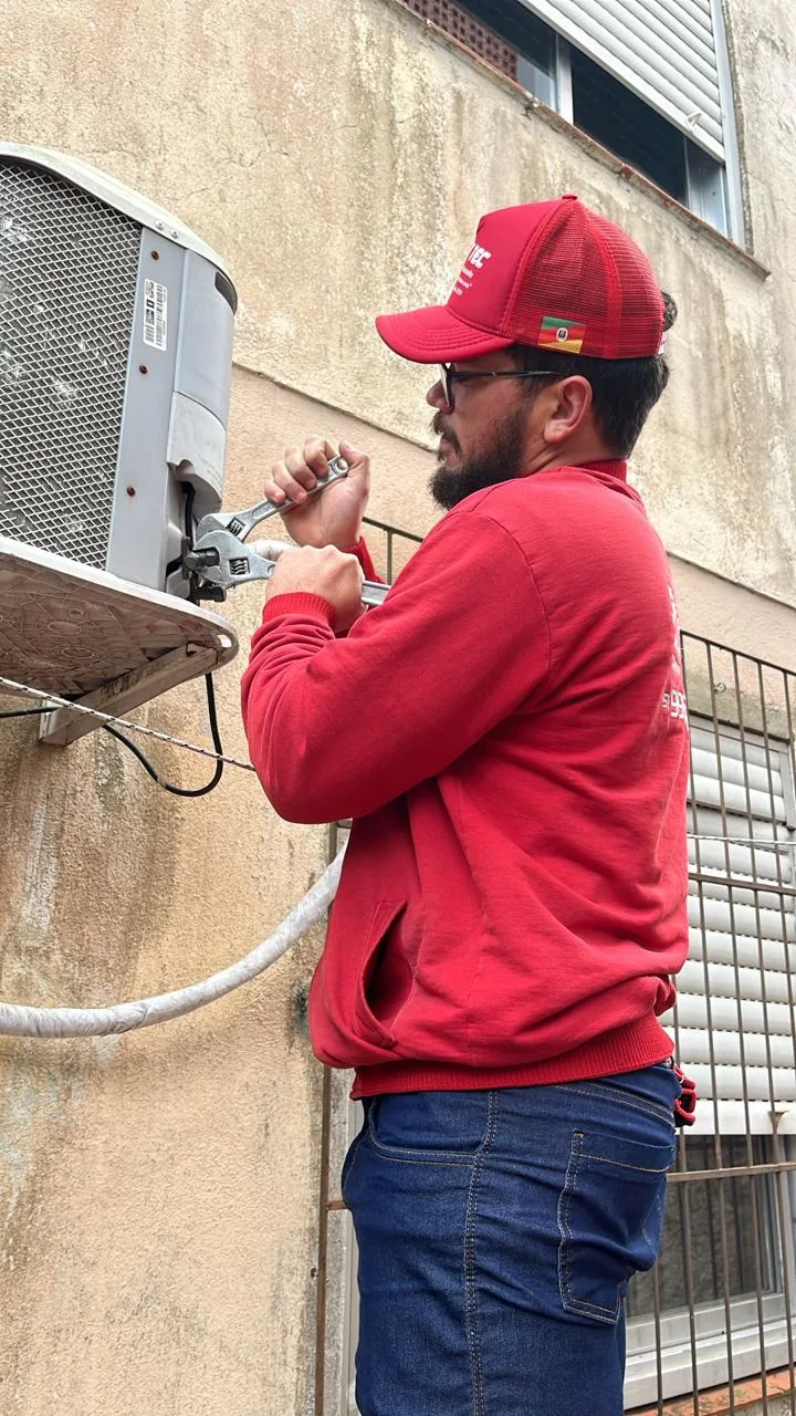 Técnico realizando manutenção em unidade externa de climatização